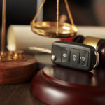 Driving While Impaired Cases – Should I Blow? - Wooden referee hammer and car keys on the table-top view