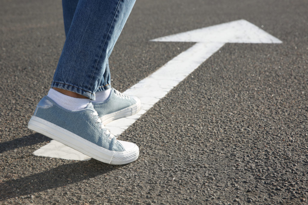 Davis, Johnson & Kallal| Wyoming Law - Woman going along road with arrow marking, closeup